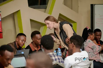 A coach helping participants with their code