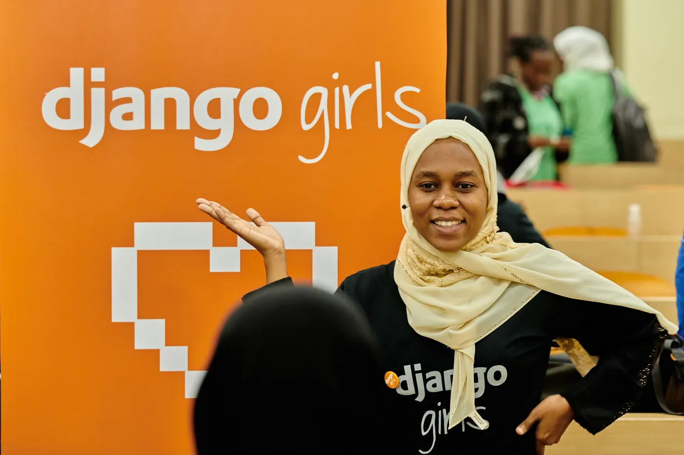A participant posing proudly beside the Django Girls banner